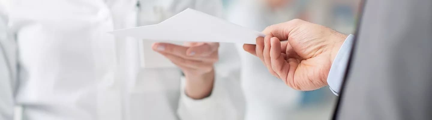 Two people passing a piece of paper.